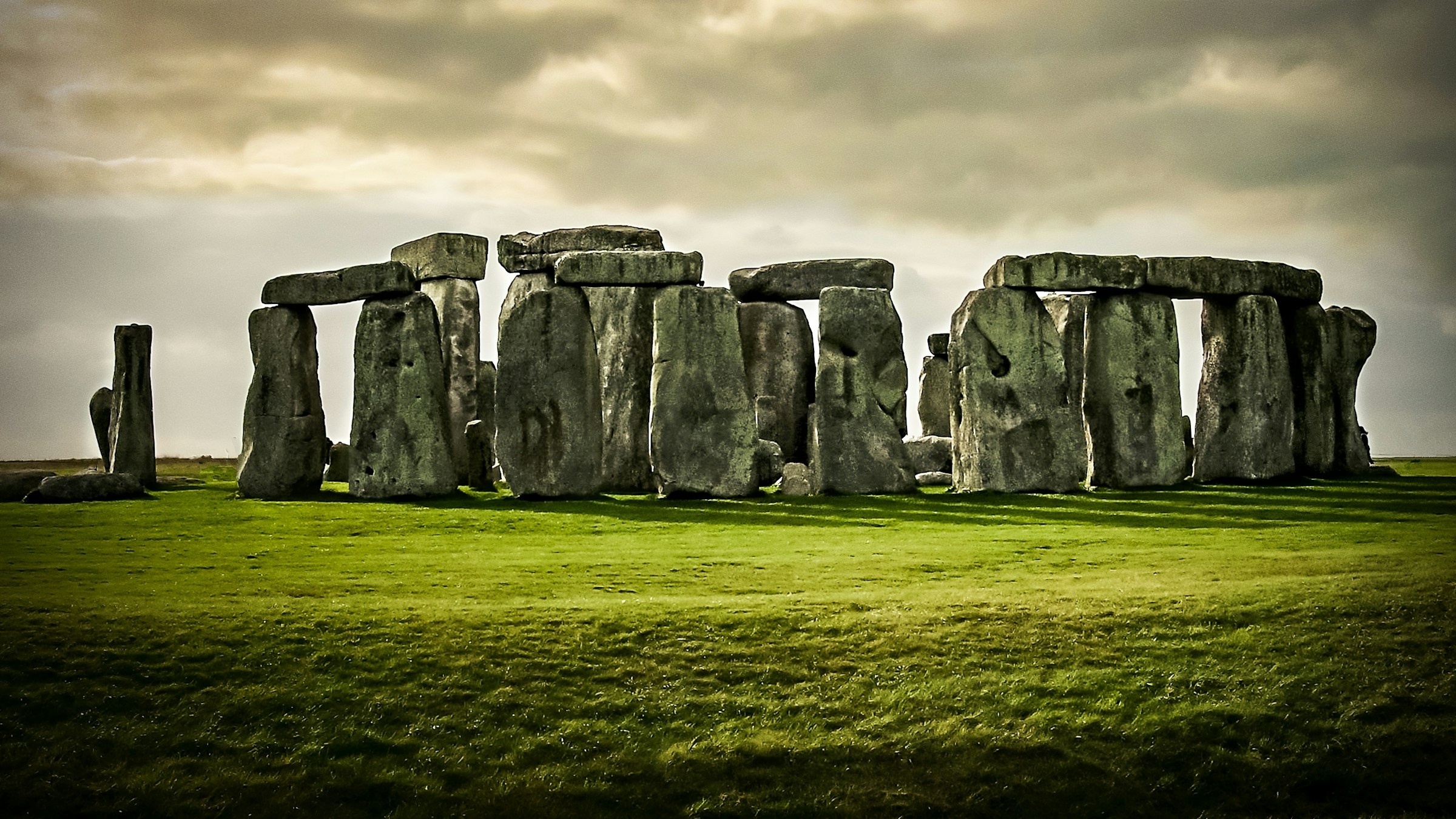 Close view of weathered sarsen boulders at Stonehenge against a pale sky