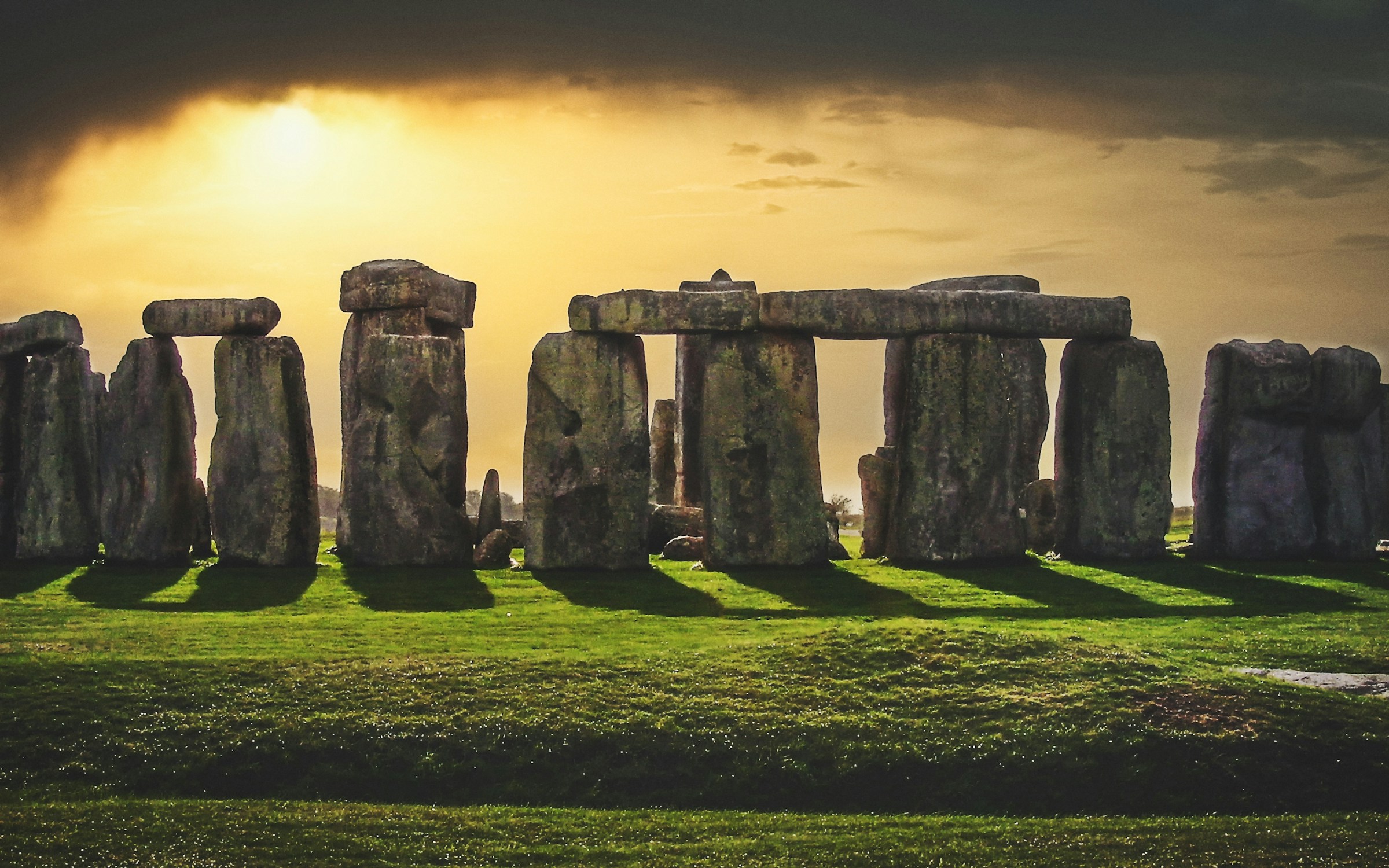 Stonehenge silhouetted against a warm sunset sky over the Salisbury Plain