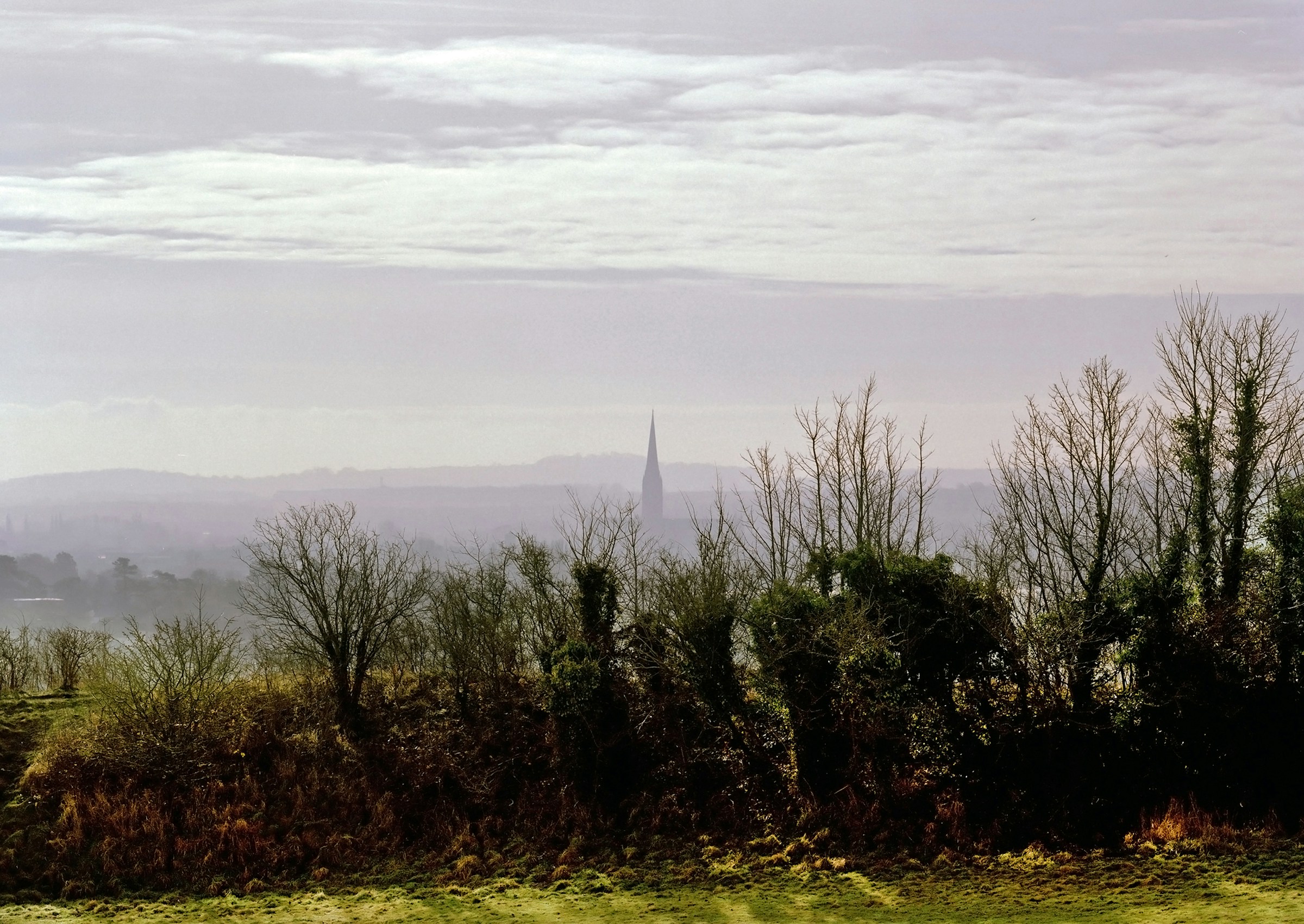 Salisbury Cathedral's spire seen in the distance from the earthworks of Old Sarum