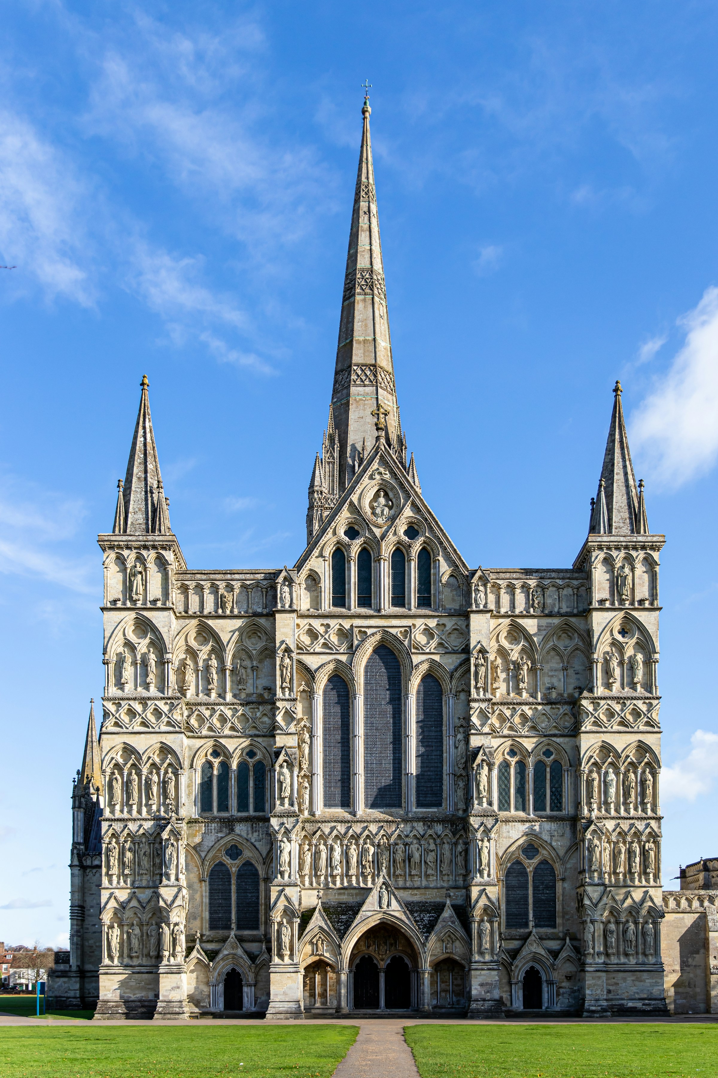 The stone façade of Salisbury Cathedral against a clear blue sky